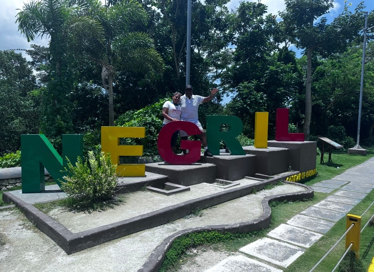 Posing at the Negril sign in Jamaica